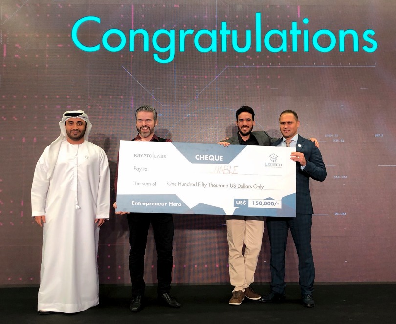 Fundadores da TiX Tecnologia Assistiva Recebem cheque de 150 mi dólares no palco da Krypto Labs, em Abu Dhabi, nos Emirados Árabes.